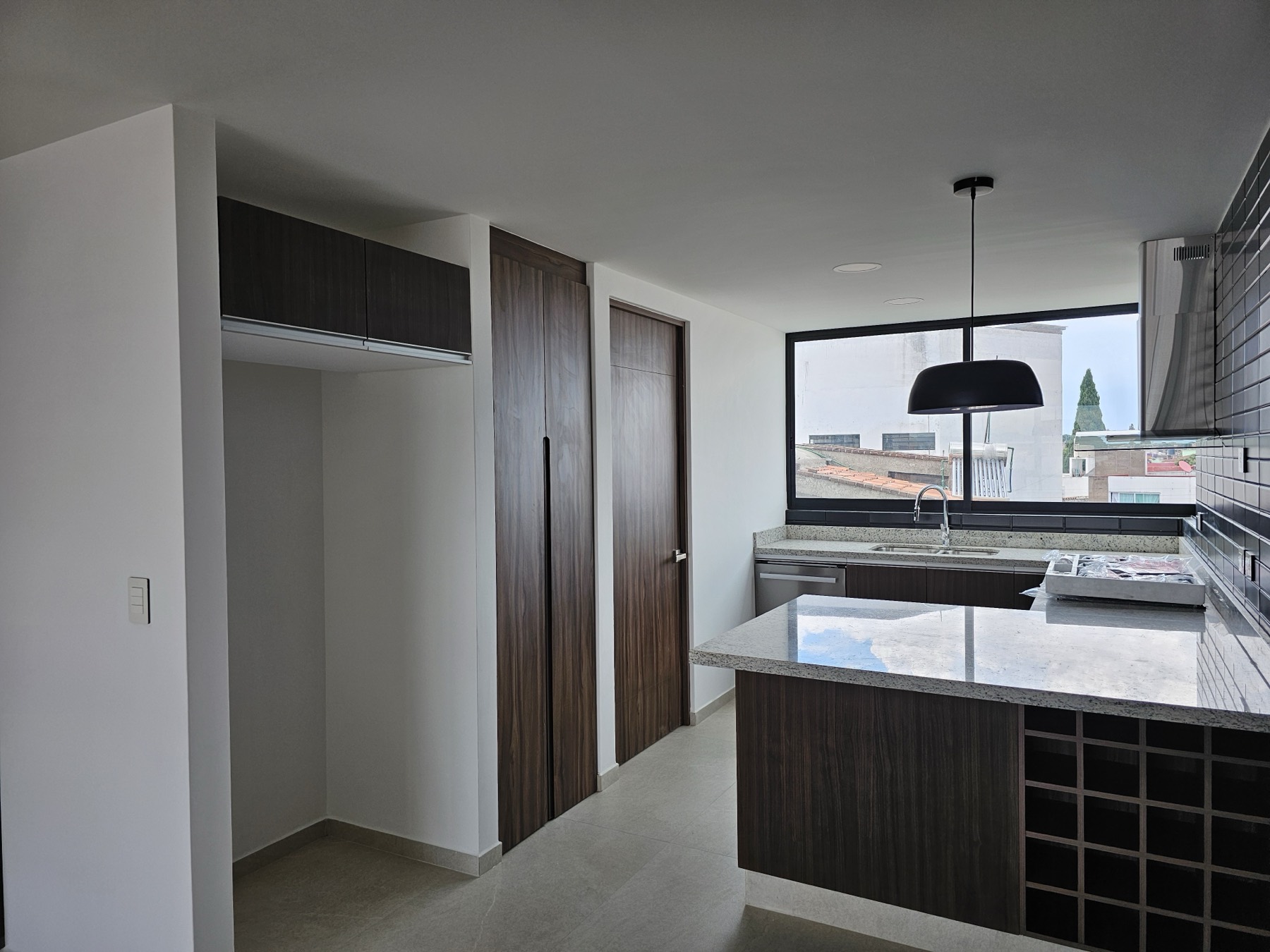 Cocina equipada con barra, cubierta de piedra y carpintería oscura